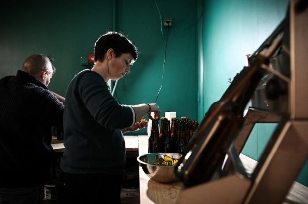 Founders of the small beer brasserie "Y'a Une Sorciere Dans Ma Biere" ("There's a Witch in my Beer") Vero Lanceron, 44, (R) and her partner Vero Verisson, 49, (L,background) bottle beer in their brasserie on April 7, 2022, in La Reole, southwestern France. STORY: French brewers return beer to its feminine roots