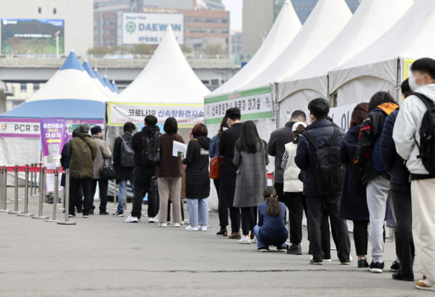 People stand in line to take coronavirus tests in Seoul Station
