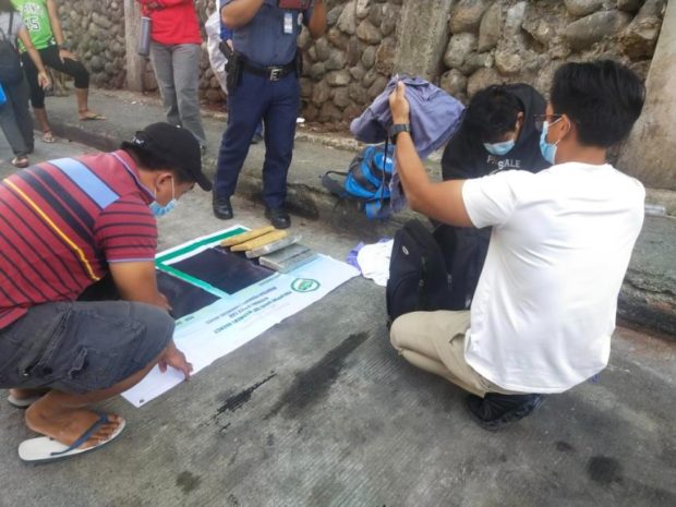 PNP personnel conducts an inventory of the contraband seized from the suspect. Image from PNP-PIO