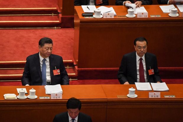 China's President Xi Jinping (L) and Premier Li Keqiang (R) attend the opening session of the National People's Congress (NPC) at the Great Hall of the People in Beijing on March 5, 2022. (Photo by Leo RAMIREZ / AFP)