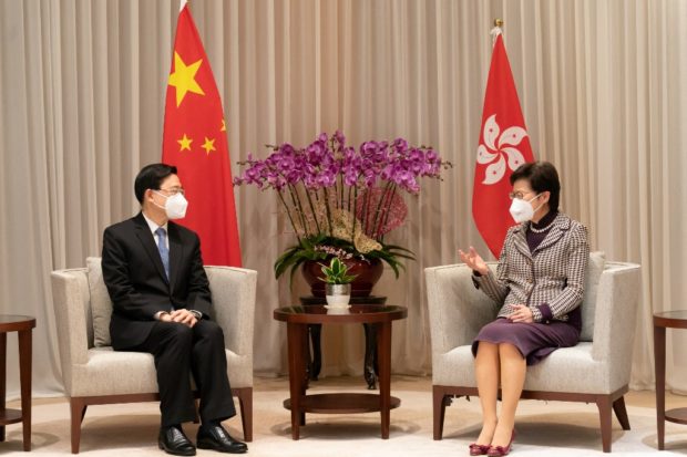 Hong Kong Chief Executive-elect John Lee (L) speaks with Chief Executive Carrie Lam during their meeting at the Central Government Complex ahead of a press conference in Hong Kong on May 9, 2022. - Lee, the former security chief who oversaw the crackdown on Hong Kong's democracy movement was anointed the business hub's new leader on May 8 by a small committee of Beijing loyalists. (Photo by Anthony Kwan / POOL / AFP)