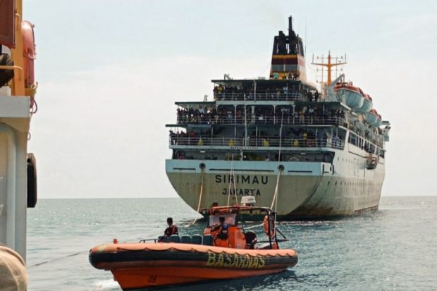 Indonesian rescuers evacuate hundreds of passengers from the KM Sirimau ferry off the coast of Lembata on May 19, 2022. - The KM Sirimau has been marooned for two days with 784 passengers and 55 crew members on board after it ran aground along a 184-kilometre (114-mile) route in East Nusa Tenggara province. (Photo by ATAGORAN / AFP)