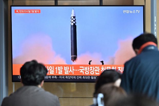 (FILES) This file picture taken on May 4, 2022 shows people watching a television screen showing a news broadcast with file footage of a North Korean missile test, at a railway station in Seoul. - North Korea has completed preparations for a nuclear test and is seeking the best moment to carry it out, a South Korean lawmaker said on May 19, 2022, a day before US President Joe Biden is due to arrive in Seoul. (Photo by JUNG YEON-JE / AFP)