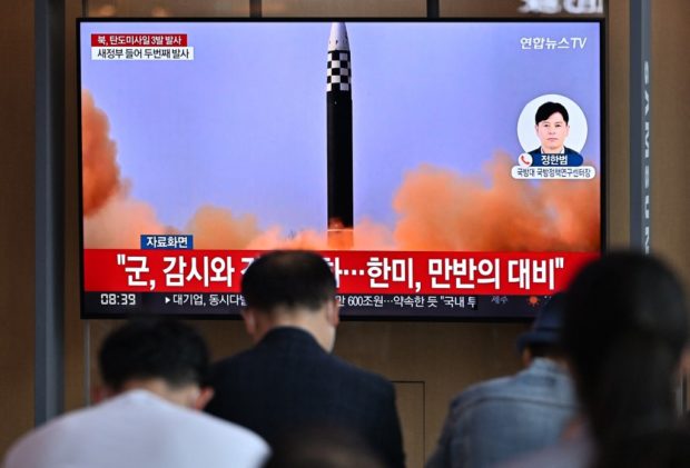 People watch a television screen showing a news broadcast with file footage of a North Korean missile test, at a railway station in Seoul on May 25, 2022, after North Korea fired three ballistic missiles towards the Sea of Japan according to South Korea's military. (Photo by JUNG YEON-JE / AFP)