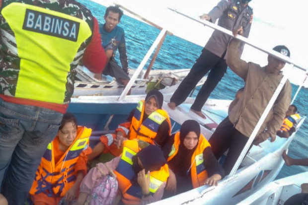This handout picture taken and released on May 28, 2022 by the Indonesian Search and Rescue Agency (BASARNAS) shows a rescue team evacuating some survivors after a ferry with 43 passengers sank in the the Makassar strait. - Twenty-six people were missing on May 28 after a ferry ran out of fuel and sank in bad weather off the coast of Indonesia, officials said. (Photo by Handout / Indonesia Search and Rescue (BASARNAS) / AFP) / RESTRICTED TO EDITORIAL USE - MANDATORY CREDIT "AFP PHOTO / Indonesia Search and Rescue Agency (BASARNAS) " - NO MARKETING - NO ADVERTISING CAMPAIGNS - DISTRIBUTED AS A SERVICE TO CLIENTS