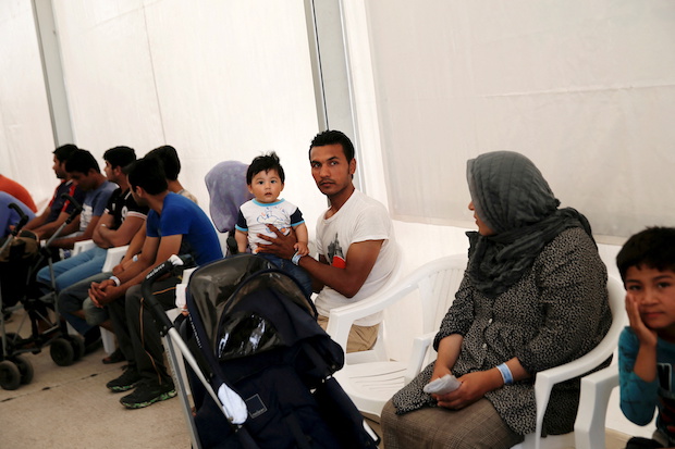 Refugees and migrants wait as they take part in a pre-registration process that gives them access to the asylum procedure, at the premises of the disused Hellenikon airport. STORY: Number of child asylum seekers in EU soared in 2021