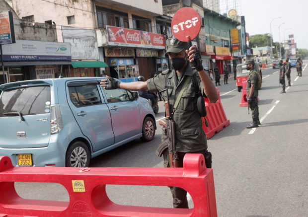 FILE PHOTO: An army member stops vehicles at a check point on a the main road after the curfew was extended for another extra day following a clash between Anti-government demonstrators and Sri Lanka's ruling party supporters, amid the country's economic crisis, in Colombo, Sri Lanka, May 11, 2022. REUTERS/Dinuka Liyanawatte/File Photo