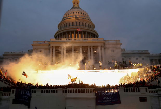 An explosion caused by a police munition is seen while supporters of U.S. President Donald Trump riot in front of the U.S. Capitol Building in Washington, U.S., January 6, 2021. 