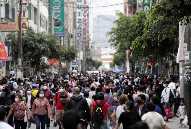 People walk in a crowded street as new cases of the coronavirus disease (COVID-19), driven by the Omicron variant, are surging, in Lima, Peru January 12, 2022. Picture taken January 12, 2022. REUTERS/Angela Ponce