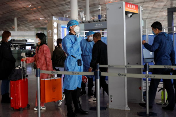 FILE PHOTO: Medical staff members check the temperature of people as they enter at Capital Airport, following an outbreak of the coronavirus disease (COVID-19), in Beijing, China, November 5, 2020. REUTERS/Thomas Peter