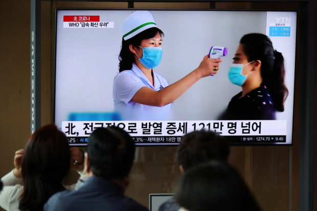 FILE PHOTO: People watch a TV broadcasting a news report on the coronavirus disease (COVID-19) outbreak in North Korea, at a railway station in Seoul, South Korea, May 17, 2022.    REUTERS/Kim Hong-Ji