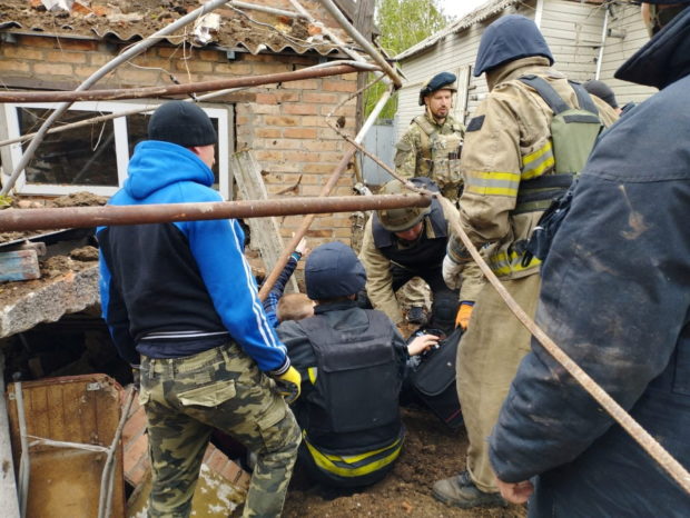 Police officers help rescue people from the rubble after an air strike, during Russia's invasion of Ukraine, in Bakhmut, Donetsk Region, Ukraine, in this handout picture released May 19, 2022 State Emergency Service of Ukraine/Handout via REUTERS