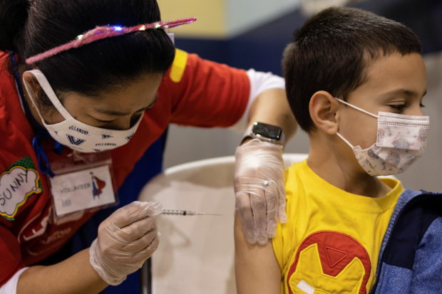 FILE PHOTO: Jace Quinones, 7, receives the Pfizer-BioNTech coronavirus disease (COVID-19) vaccine in Lansdale, Pennsylvania, U.S., December 5, 2021. REUTERS/Hannah Beier
