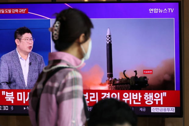 A woman watches a TV broadcasting a news report on North Korea's launch of three missiles what appeared to have involved an intercontinental ballistic missile (ICBM), in Seoul, South Korea, May 25, 2022. REUTERS/Kim Hong-Ji