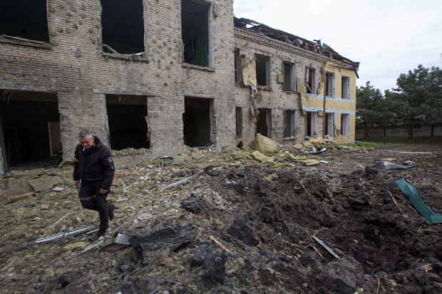 A police officer walks next to a school building damaged by a Russian military strike, as Russia's attack on Ukraine continues, in the settlement of Kostiantynivka, in Donetsk region, Ukraine May 22, 2022. Picture taken May 22, 2022.  REUTERS/Anna Kudriavtseva