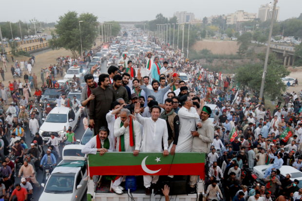 Ousted Pakistani Prime Minister Imran Khan gestures as he travels on a vehicle to lead a protest march in Islamabad, Pakistan May 26, 2022. REUTERS/Akhtar Soomro