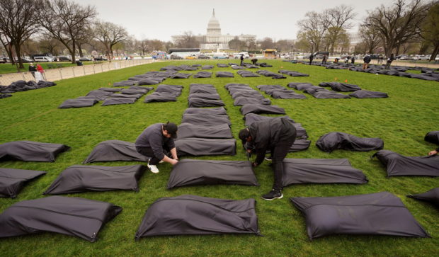 FILE PHOTO: Some of the 1,100 body bags that will spell out the words “Thoughts and Prayers” are placed on the National Mall near the U.S. Capitol as gun control activists demand Congress do more to end gun violence in Washington, U.S., March 24, 2022. REUTERS/Kevin Lamarque