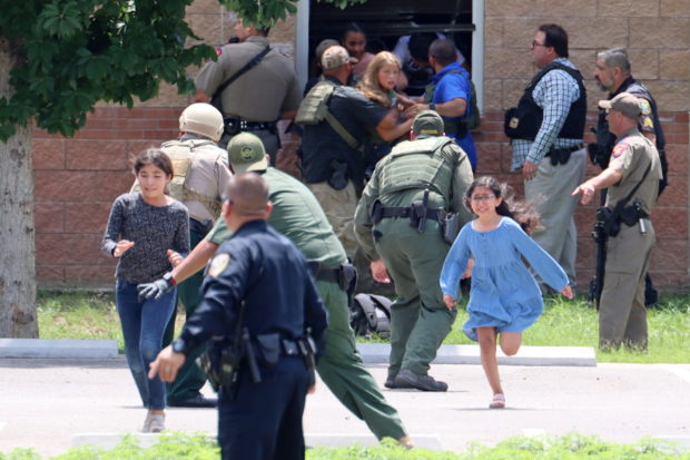 Children run to safety after escaping from a window during a mass shooting at Robb Elementary School where a gunman killed nineteen children and two adults in Uvalde, Texas, U.S. May 24, 2022. Picture taken May 24, 2022.  Pete Luna/Uvalde Leader-News/Handout via REUTERS