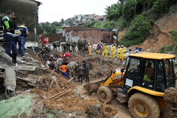 Firefighters, volunteers and army officers work on the site where a house collapsed due to a landslide caused by heavy rains at Jardim Monte Verde, in Ibura neighbourhood, in Recife, Brazil, May 29, 2022. REUTERS/Diego Nigro
