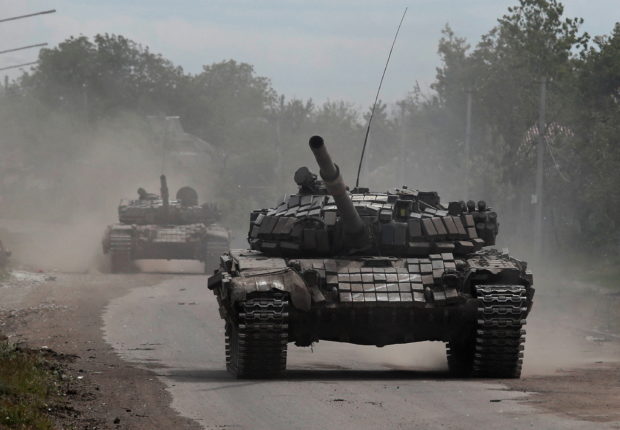 FILE PHOTO: Tanks of pro-Russian troops drive along a street during Ukraine-Russia conflict in the town of Popasna in the Luhansk Region, Ukraine May 26, 2022. REUTERS/Alexander Ermochenko/File Photo