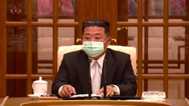 This photo, captured from North Korea’s Korean Central TV, shows leader Kim Jong-un wearing a face mask as he presides over a politburo meeting of the ruling Workers’ Party over the North’s first known case of COVID-19 in Pyongyang on Thursday