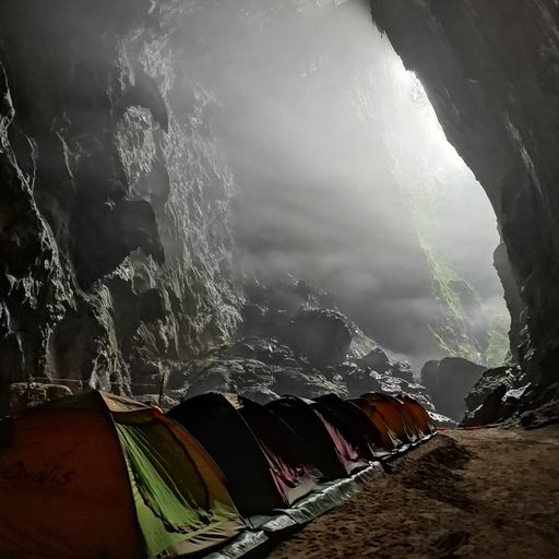 CAVE CAMP: Tents for explorers to spend the night must be set up by the pros, under shining light from the doline nearby.