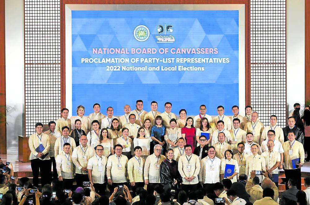 Majority of the 62 representatives of the 55 party list groups that were proclaimed winners on Thursday pose for a picture with officials of the Commission on Elections.