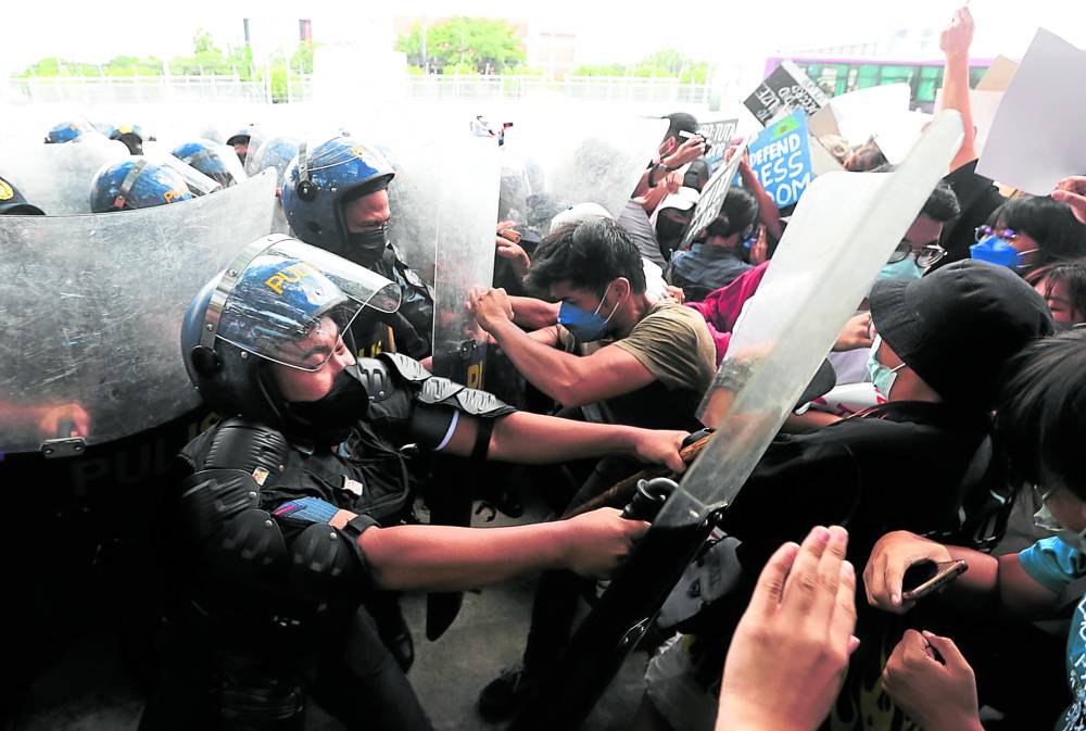 IT’S 2022, NOT 1985  Riot policemen get rough with insistent protesters on the road to the Batasang Pambansa where President-elect Ferdinand Marcos Jr. was proclaimed on Wednesday.—NIÑO JESUS ORBETA