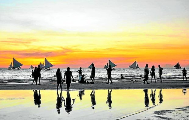 People on a Boracay beach at sunset
