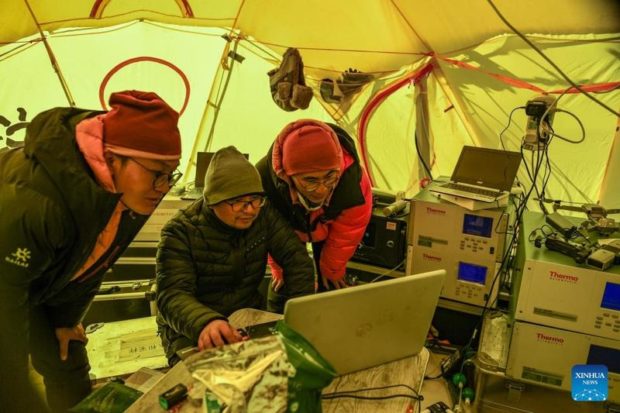 Scientific research members check atmospheric data at the Mount Qomolangma base camp on May 3, 2022