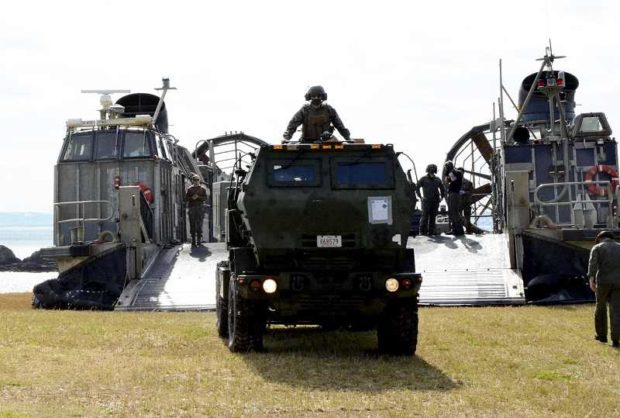 A vehicle is driven off a U.S. Landing Craft Air Cushion on a beach in Kin, Okinawa Prefecture, in February