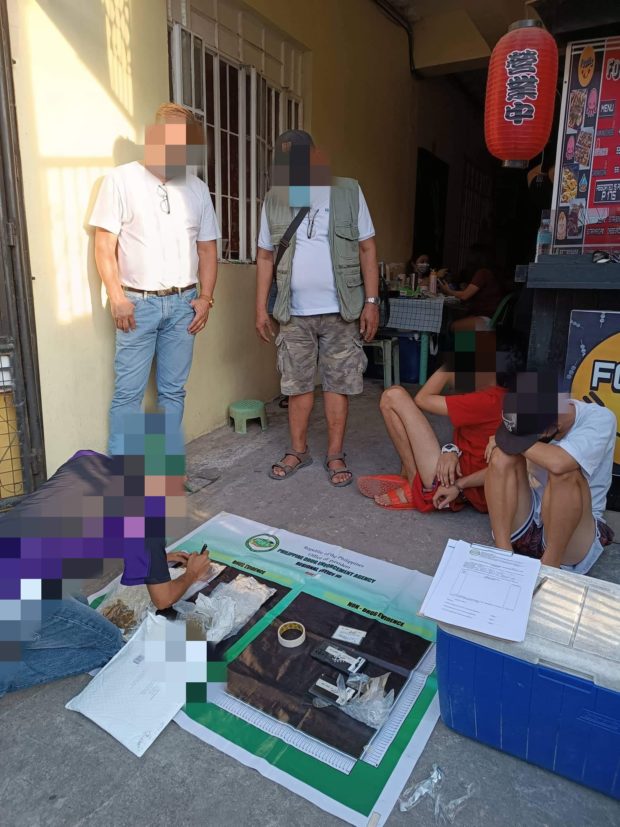 Undercover government operatives inspect the P325,000 worth of kush discovered at the Bureau of Customs-Port of Clark