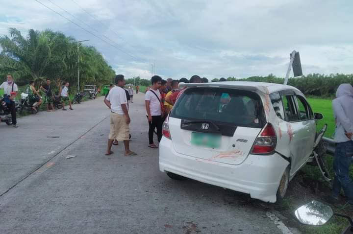 Civilians view the white Honda fit vehicle driven by Baimhon Ambalgan following the ambush on Monday.