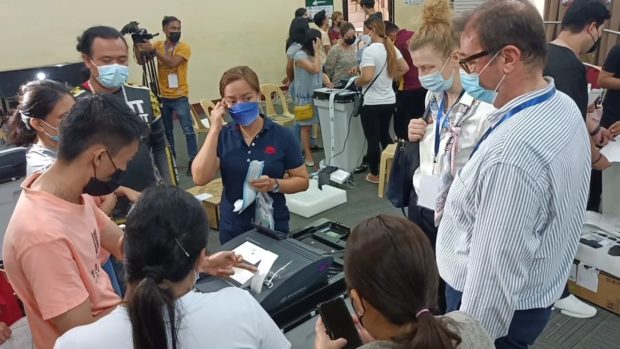 Officials of the Commission on Elections (Comelec) lead the final testing and sealing of the vote counting machines. STORY: On eve of vote, VCM final testing yet to be completed