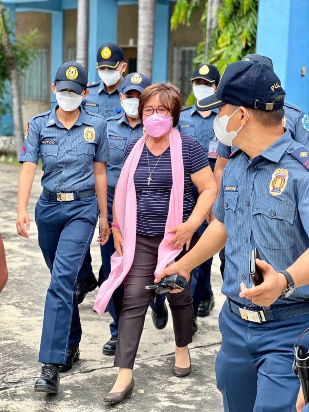 Detained Senator Leila De Lima, who is running for reelection, is escorted by her police security detail. CONTRIBUTED PHOTO