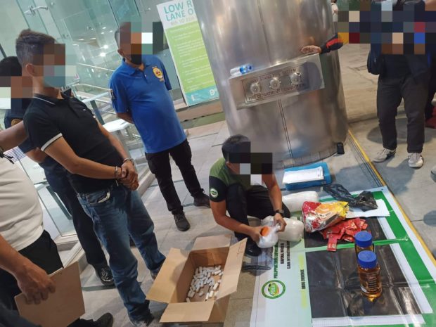 Government operatives inspect the cannabis oil discovered at the Port of Clark in Pampanga province after conducting an entrapment operation on May 19 against the package consignee. (Photo courtesy of PDEA-3) 