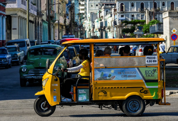 An electric powered tricycle rides along a street of Havana on May 25, 2022. - Cubans are opting for motorcycles, tricycles and electric cars in the face of the public transportation and fuel shortage crisis. (Photo by Yamil LAGE / AFP)