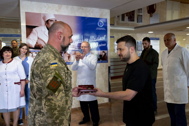 This handout picture taken and released by Ukrainian Presidential Press Service on June 3, 2022 shows Ukrainia's President Volodymyr Zelensky (R) presenting words to a wounded Ukrainian serviceman at the Shalimov National Institute of Surgery and Transplantology in Kyiv, on the 100th day of the Russian invasion of Ukraine. - Volodymyr Zelensky vowed victory on the 100th day of Russia's invasion on June 3, 2022, even as Russian troops pounded the eastern Donbas region. (Photo by UKRAINIAN PRESIDENTIAL PRESS SERVICE / AFP) / -----EDITORS NOTE --- RESTRICTED TO EDITORIAL USE - MANDATORY CREDIT "AFP PHOTO / HANDOUT/Ukrainian Presidential Press Service " - NO MARKETING - NO ADVERTISING CAMPAIGNS - DISTRIBUTED AS A SERVICE TO CLIENTS - NO ARCHIVES