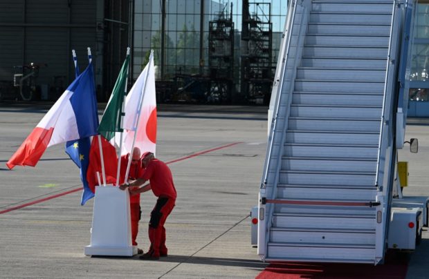 Airport staff set up the flags of Japan, Italy, France and the EU prior to the arrival of G7 leaders at the Franz Josef Strauss Airport in Munich, southern Germany