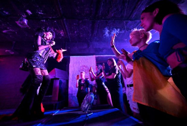 Revellers watch a performance in a nightclub during an LGBTQ event 