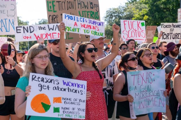 Abortion rights demonstrators hold signs as they gather near the State Capitol in Austin, Texas