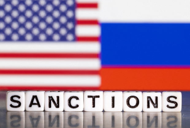 FILE PHOTO: Plastic letters arranged to read "Sanctions" are placed in front the flag colors of U.S. and Russia in this illustration taken February 28, 2022. REUTERS/Dado Ruvic/Illustration/File Photo