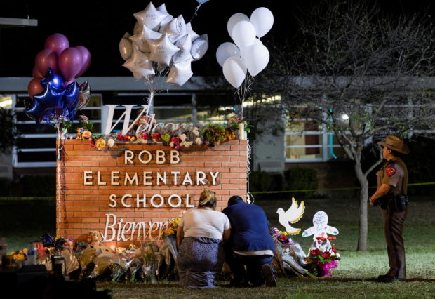 Stephanie and Michael Chavez of San Antonio pay their respects at a makeshift memorial outside Robb Elementary School, the site of a mass shooting, in Uvalde, Texas, U.S., May 25, 2022. REUTERS/Nuri Vallbona