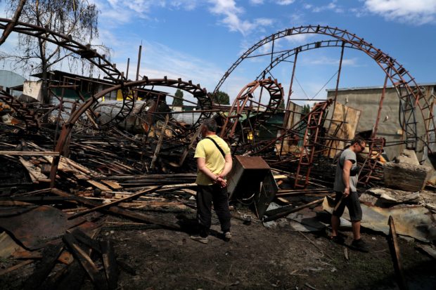 Workers inspect a damaged wood warehouse after a strike, amid Russia's attack on Ukraine, in the outskirt of Kharkiv, Ukraine June 3, 2022. REUTERS/Ivan Alvarado