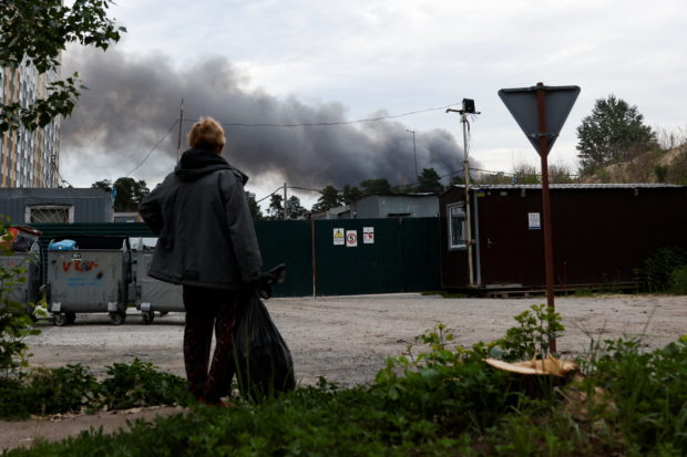 A man looks at the smoke after explosions were heard as Russia's attacks on Ukraine continues, in Kyiv, Ukraine June 5, 2022. REUTERS/Edgar Su