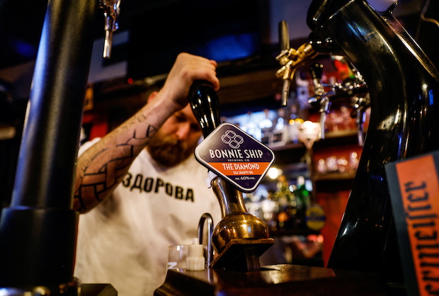 A bartender pours beer at a bar in Moscow. STORY: Little cheer for Russian beer lovers as sanctions bite