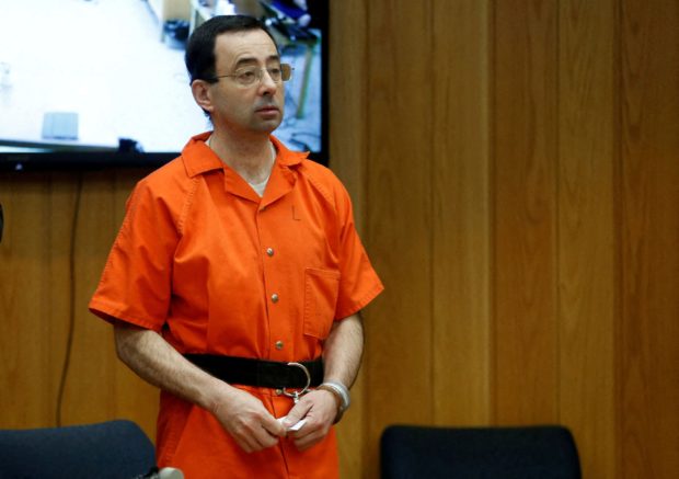 FILE PHOTO: Larry Nassar, a former team USA Gymnastics doctor who pleaded guilty in November 2017 to sexual assault charges, stands in court during his sentencing hearing in the Eaton County Court in Charlotte, Michigan, U.S., February 5, 2018.  REUTERS/Rebecca Cook/File Photo/File Photo