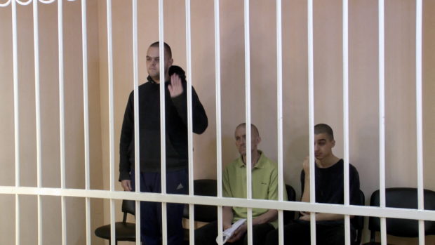 A still image, taken from footage of the Supreme Court of the self-proclaimed Donetsk People's Republic, shows Britons Aiden Aslin, Shaun Pinner and Moroccan Brahim Saadoun captured by Russian forces during a military conflict in Ukraine, in a courtroom cage at a location given as Donetsk, Ukraine, in a still image from a video released June 7, 2022. Video taken June 7, 2022. Supreme Court of Donetsk People's Republic/Handout via REUTERS