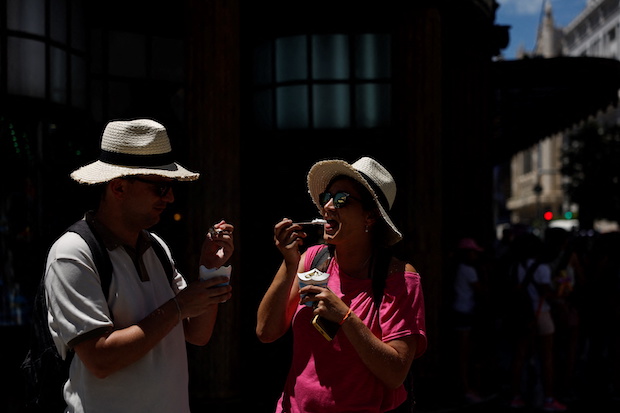 People eat ice cream on a hot day as Spain braces for a heatwave in Madrid. STORY: Spain swelters in hottest pre-summer heatwave in 20 years