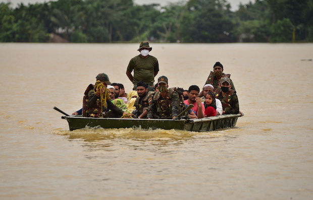 Indian Army soldiers evacuate people from flooded area to a safer place after heavy rains at a village in Hojai district. STORY: Millions stranded as floods ravage parts of Bangladesh, India